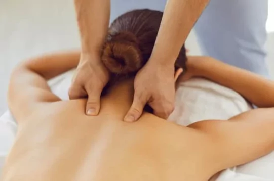 choosing a massage therapy school. Image of a woman receiving a shoulder massage.